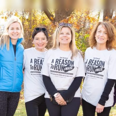 Mandi, Reid, Michelle, and Melissa, the founders of Reason to Run, together outdoors in their event T-shirts